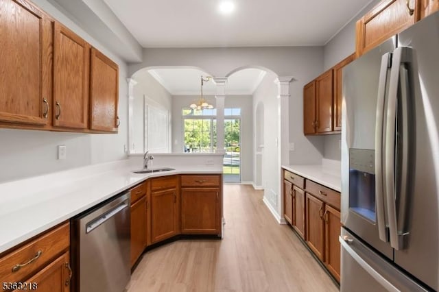 133 Marlboro Cir, Lopatcong Twp, NJ 08886 - kitchen featuring appliances with stainless steel finishes, a sink, arched walkways, light wood-style flooring, and brown cabinetry
