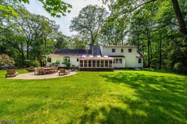 504 Pepperidge Tree Ln, Kinnelon Boro, NJ 07405 - back of house with a sunroom, a patio area, a yard, and a chimney