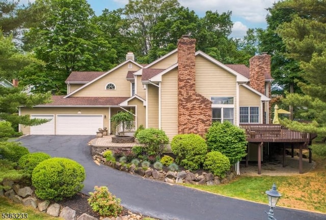 21 Stafford Ln, Bedminster Twp, NJ 07921 - view of front of property featuring asphalt driveway, a garage, a wooden deck, and a chimney