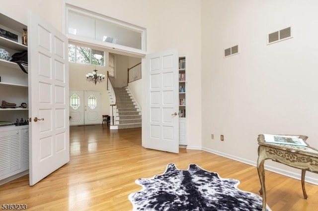 21 Stafford Ln, Bedminster Twp, NJ 07921 - living area with a high ceiling, stairway, light wood-type flooring, a chandelier, and baseboards