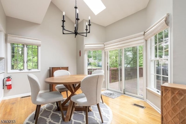 21 Stafford Ln, Bedminster Twp, NJ 07921 - dining area with a skylight, a chandelier, high vaulted ceiling, light wood finished floors, and baseboards