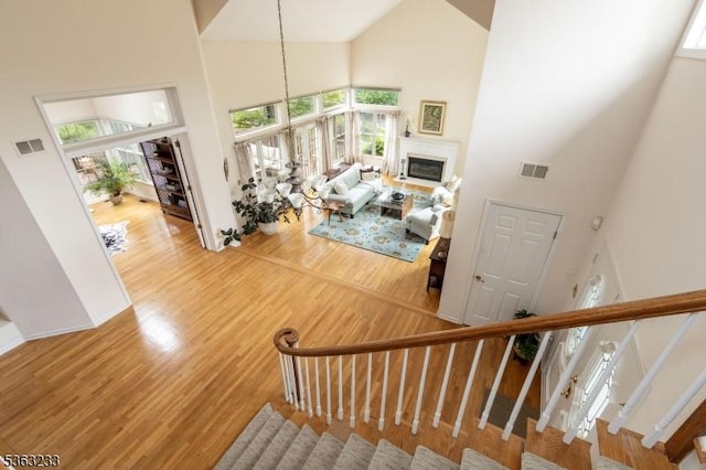 21 Stafford Ln, Bedminster Twp, NJ 07921 - stairs featuring a high ceiling, wood finished floors, and a glass covered fireplace