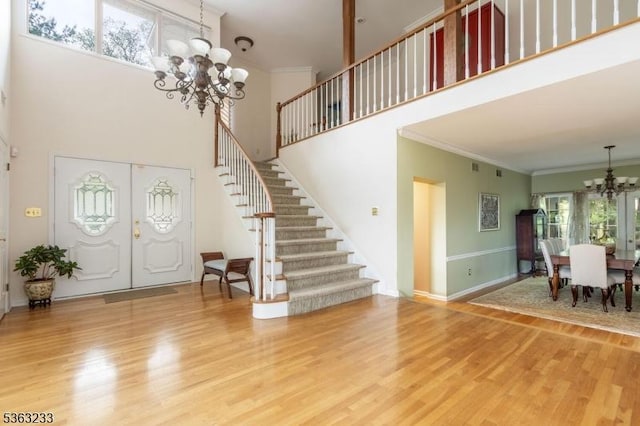 21 Stafford Ln, Bedminster Twp, NJ 07921 - foyer with a chandelier, stairway, a towering ceiling, wood finished floors, and ornamental molding