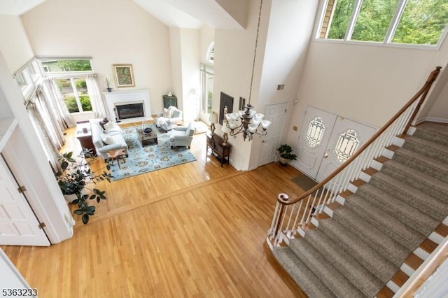 21 Stafford Ln, Bedminster Twp, NJ 07921 - living area with a high ceiling, stairs, wood finished floors, and a glass covered fireplace