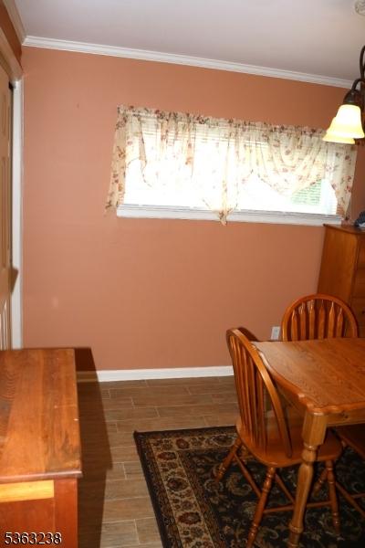 75 Sunrise Ter, Cedar Grove Twp, NJ 07009 - dining room featuring baseboards, healthy amount of natural light, ornamental molding, and light wood-type flooring