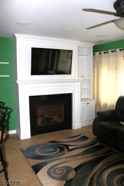 75 Sunrise Ter, Cedar Grove Twp, NJ 07009 - living room with a large fireplace, a ceiling fan, and baseboards
