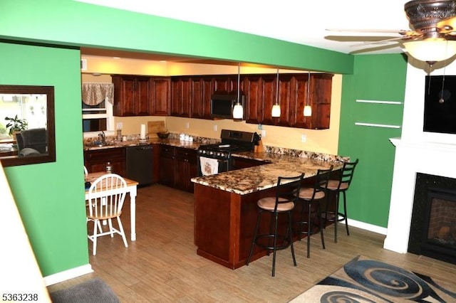 75 Sunrise Ter, Cedar Grove Twp, NJ 07009 - kitchen with black appliances, a peninsula, light wood-style floors, and a sink