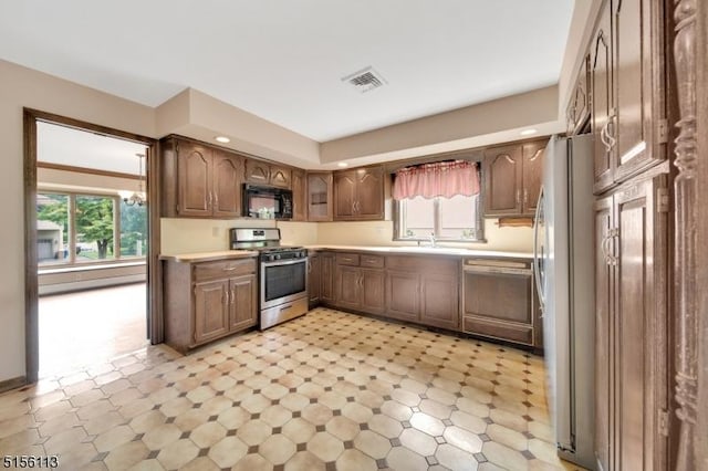 23 Bohnert Pl, Waldwick Boro, NJ 07463 - kitchen with stainless steel gas range, black microwave, dishwasher, light flooring, and light countertops