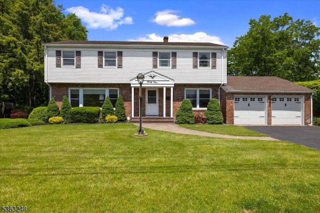 45 Churchill Rd, Cresskill Boro, NJ 07626 - colonial home with asphalt driveway, brick siding, a garage, a front yard, and a chimney