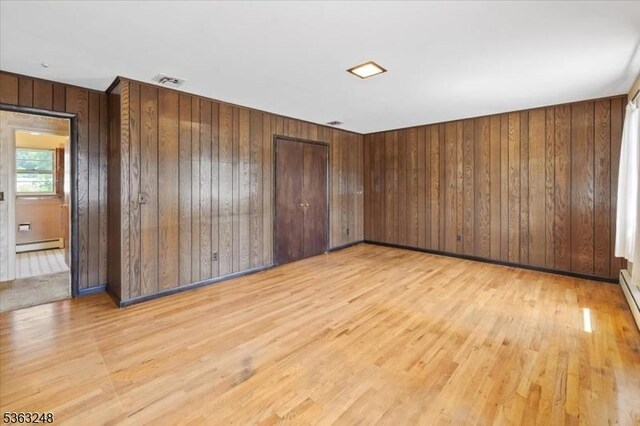 45 Churchill Rd, Cresskill Boro, NJ 07626 - empty room with baseboard heating, light wood-type flooring, and wooden walls
