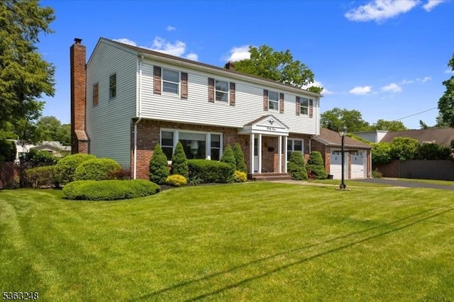 45 Churchill Rd, Cresskill Boro, NJ 07626 - colonial home with an attached garage, brick siding, driveway, a chimney, and a front yard