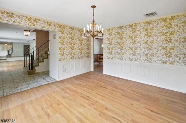 45 Churchill Rd, Cresskill Boro, NJ 07626 - empty room with a chandelier, wallpapered walls, wainscoting, stairway, and wood finished floors