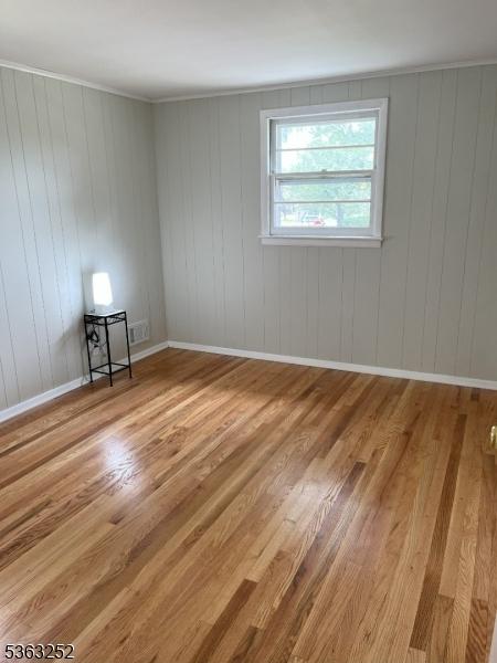 2 Perry Rd, Bloomfield Twp, NJ 07003 - spare room with light wood-style floors and wood walls