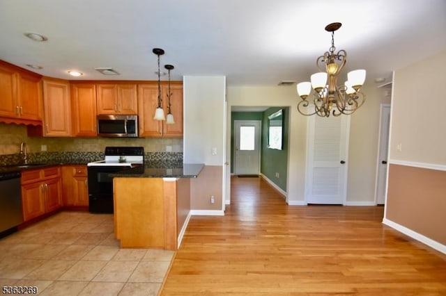 18 Apollo Dr, Jefferson Twp, NJ 07438 - kitchen featuring appliances with stainless steel finishes, tasteful backsplash, a chandelier, pendant lighting, and a peninsula