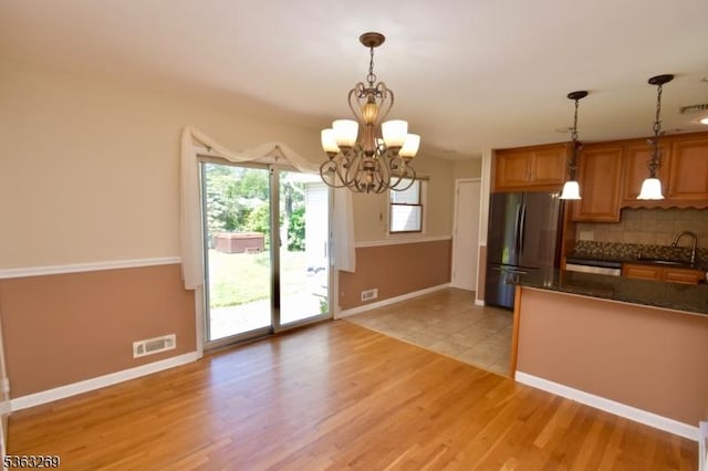 18 Apollo Dr, Jefferson Twp, NJ 07438 - kitchen with freestanding refrigerator, decorative backsplash, a chandelier, light wood-style flooring, and decorative light fixtures