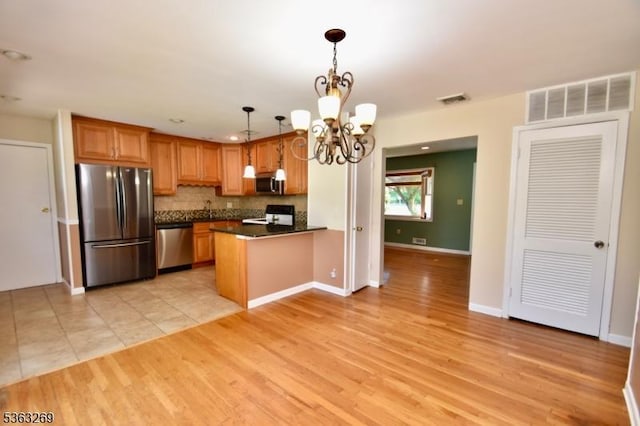 18 Apollo Dr, Jefferson Twp, NJ 07438 - kitchen with stainless steel appliances, dark countertops, a chandelier, backsplash, and a peninsula