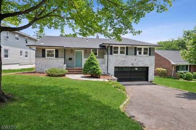 30 Mountain Way W, Orange Twp, NJ 07052 - split level home featuring asphalt driveway, a garage, a front yard, brick siding, and a chimney