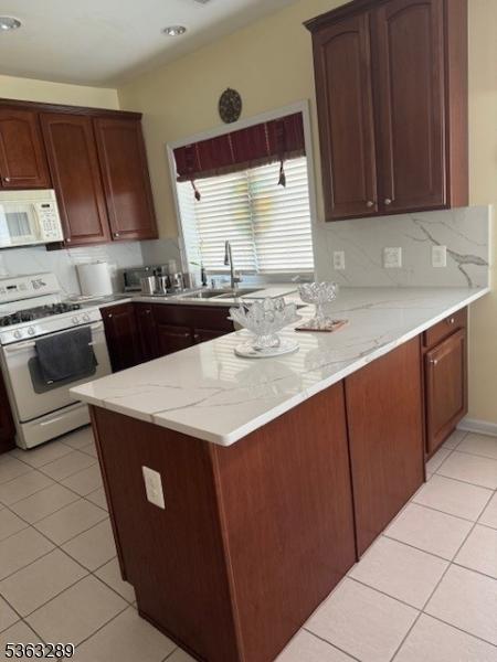 515 Crossfields Ln, Franklin Twp, NJ 08873 - kitchen with white appliances, a sink, light tile patterned floors, and a peninsula