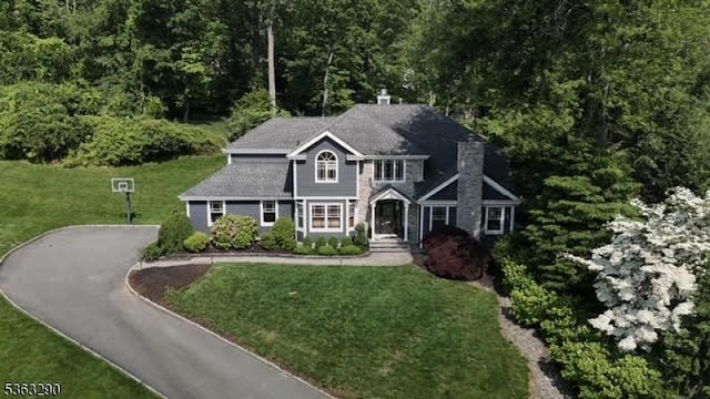 14 Mount Freedom Ave, Randolph Twp, NJ 07869 - view of front facade featuring asphalt driveway, a front lawn, a chimney, and a wooded view