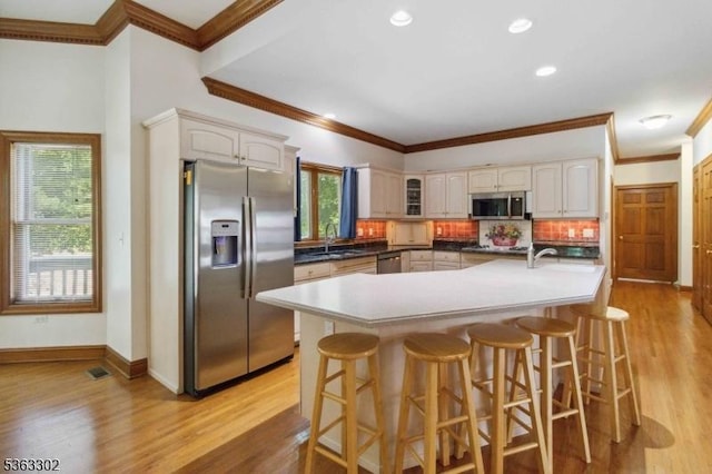 13 E Cove Ln, Morris Twp, NJ 07960 - kitchen with stainless steel appliances, ornamental molding, light wood-style flooring, glass insert cabinets, and tasteful backsplash