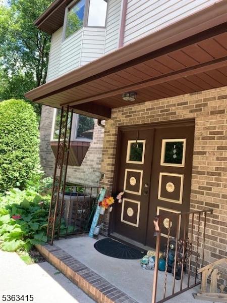 678 Broad St Unit A-4, Clifton City, NJ 07013 - doorway to property with brick siding and central AC