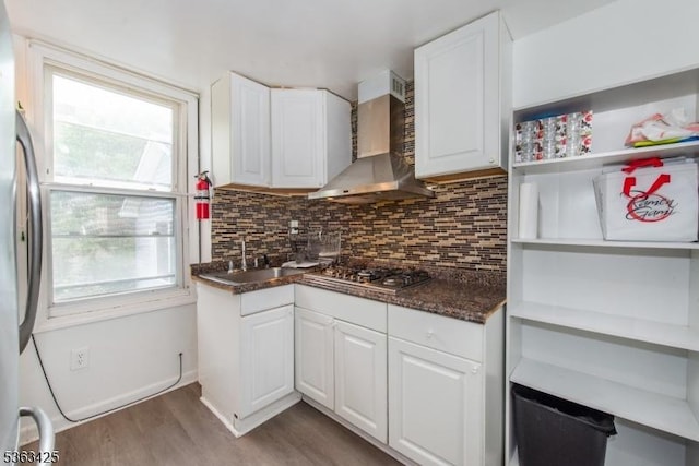 56 Holsman St Unit 2, Paterson City, NJ 07522 - kitchen featuring wall chimney exhaust hood, wood finished floors, stainless steel appliances, decorative backsplash, and white cabinetry