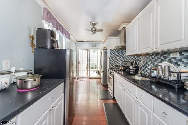 56 Holsman St Unit 2, Paterson City, NJ 07522 - kitchen featuring appliances with stainless steel finishes, a ceiling fan, decorative backsplash, white cabinetry, and wall chimney exhaust hood