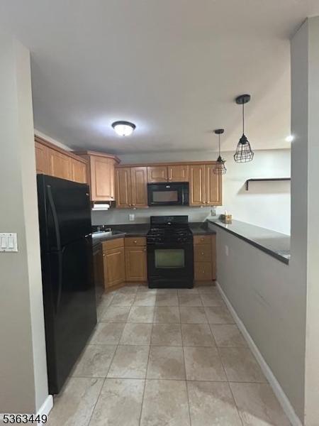 816-826 W Grand St Unit 3I, Elizabeth City, NJ 07202 - kitchen featuring black appliances, dark countertops, baseboards, brown cabinets, and hanging light fixtures