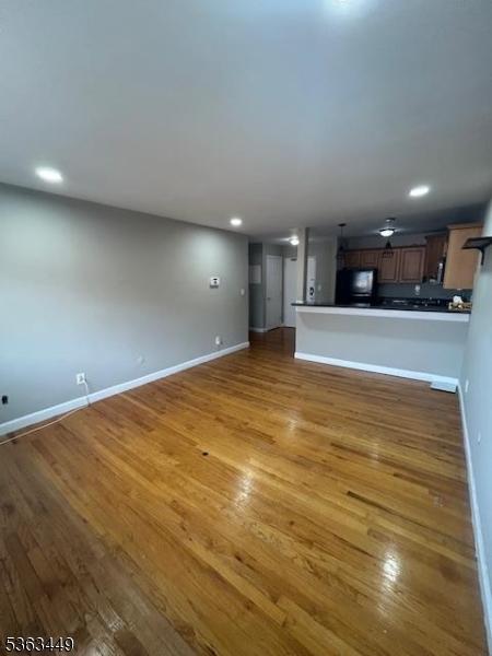 816-826 W Grand St Unit 3I, Elizabeth City, NJ 07202 - unfurnished living room featuring wood finished floors, baseboards, and recessed lighting