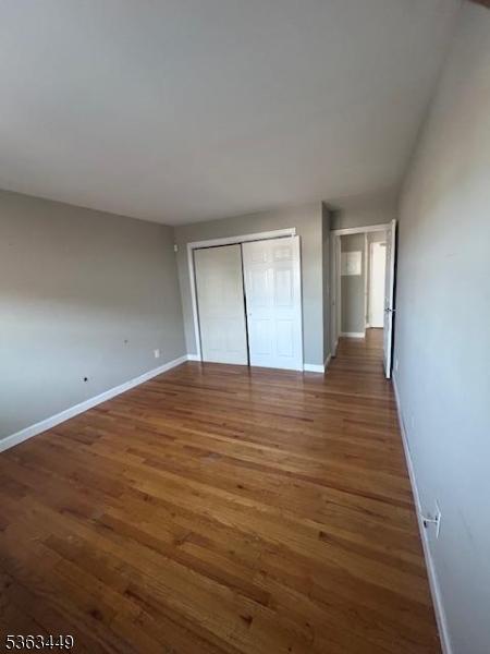 816-826 W Grand St Unit 3I, Elizabeth City, NJ 07202 - unfurnished bedroom with baseboards, wood finished floors, and a closet