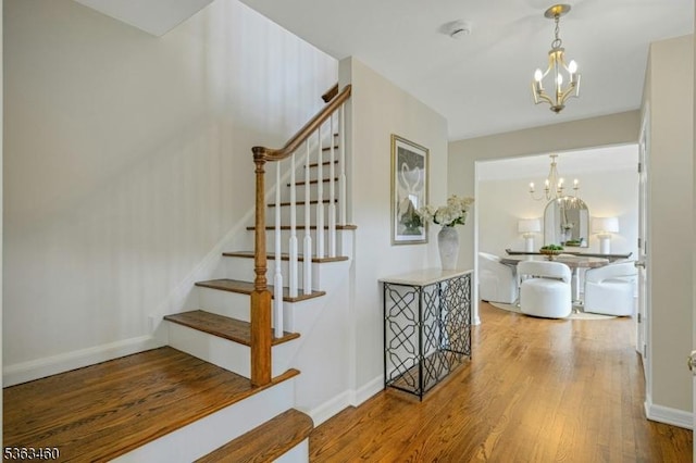 26 Brockden Dr, Mendham Twp, NJ 07945 - stairs with a chandelier, wood finished floors, and baseboards
