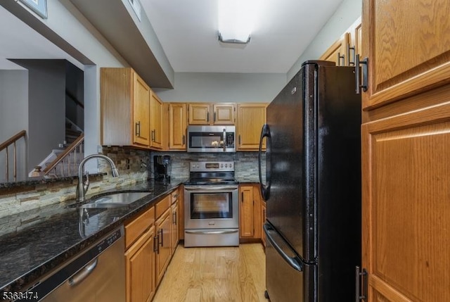 47 Crestmont Rd, Bedminster Twp, NJ 07921 - kitchen featuring appliances with stainless steel finishes, a sink, decorative backsplash, dark stone countertops, and light wood-style flooring