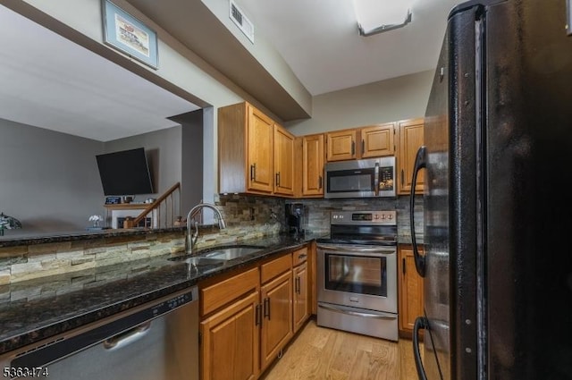 47 Crestmont Rd, Bedminster Twp, NJ 07921 - kitchen with stainless steel appliances, a sink, dark stone countertops, light wood finished floors, and decorative backsplash