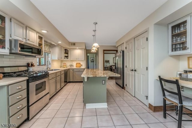 5 Fisher Ct, Raritan Twp, NJ 08822 - kitchen with stainless steel appliances, a sink, a center island, tasteful backsplash, and light tile patterned floors