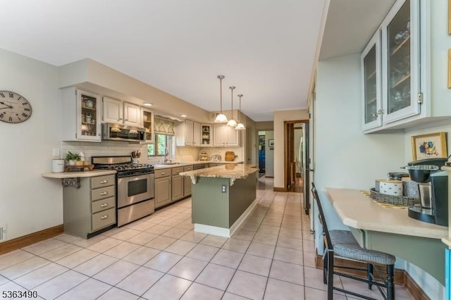 5 Fisher Ct, Raritan Twp, NJ 08822 - kitchen featuring appliances with stainless steel finishes, a kitchen island, decorative backsplash, a kitchen bar, and glass insert cabinets