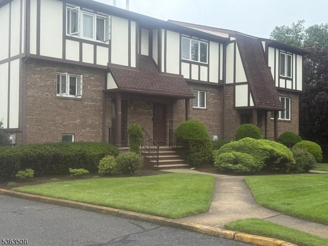 55 Canterbury Ln Unit 55, New Milford Boro, NJ 07646 - tudor home featuring brick siding, a front yard, and stucco siding