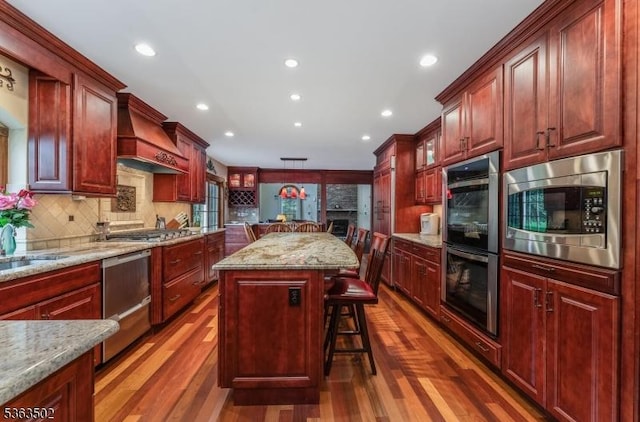 4 Fisher Ct, Raritan Twp, NJ 08822 - kitchen featuring stainless steel appliances, dark brown cabinets, a kitchen island, dark wood finished floors, and custom exhaust hood