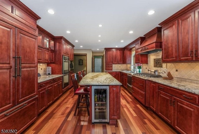 4 Fisher Ct, Raritan Twp, NJ 08822 - kitchen with wine cooler, custom exhaust hood, reddish brown cabinets, dark wood-style floors, and stainless steel appliances