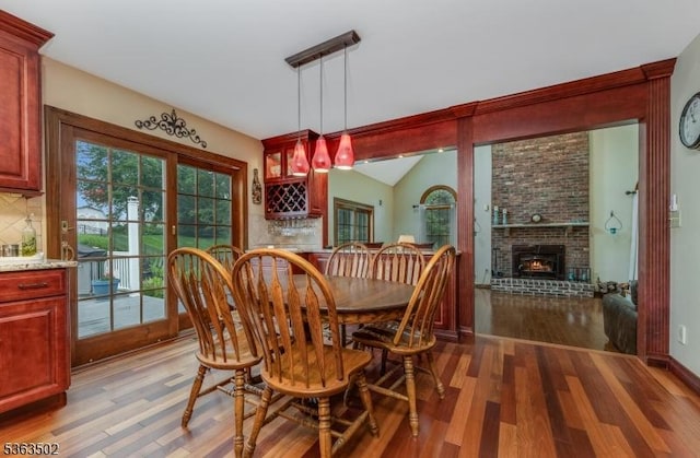 4 Fisher Ct, Raritan Twp, NJ 08822 - dining space featuring light wood-type flooring, lofted ceiling, a brick fireplace, and bar