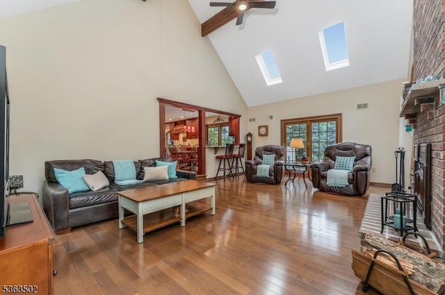 4 Fisher Ct, Raritan Twp, NJ 08822 - living room with high vaulted ceiling, a skylight, wood finished floors, a ceiling fan, and a brick fireplace