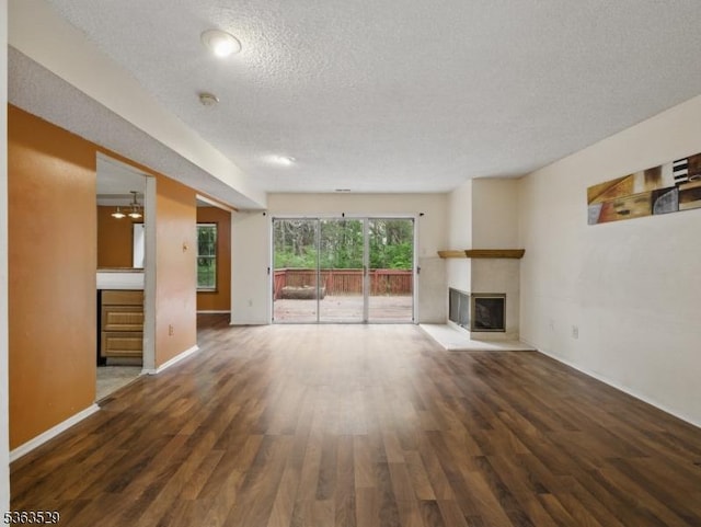 33 Avebury Pl, Franklin Twp, NJ 08873 - unfurnished living room with a glass covered fireplace, a textured ceiling, wood finished floors, and baseboards