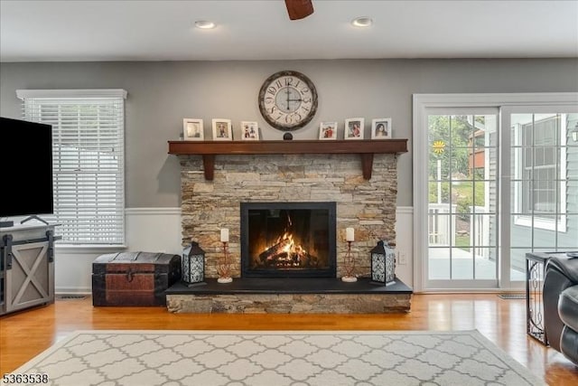 5 Brendan Dr, Mount Olive Twp, NJ 07836 - living area with wood finished floors, a stone fireplace, a wainscoted wall, a ceiling fan, and recessed lighting