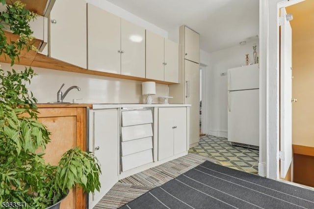 255 Ampere Pkwy, Bloomfield Twp, NJ 07003 - kitchen featuring freestanding refrigerator, light countertops, white cabinets, and light floors