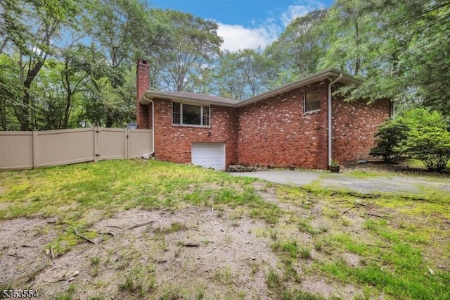 3 Christine Ct, Kinnelon Boro, NJ 07405 - view of side of property featuring a gate, a chimney, brick siding, an attached garage, and driveway