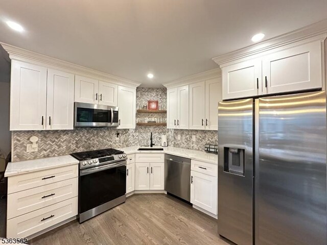 43 Kensington Ct, Washington Twp, NJ 07840 - kitchen featuring appliances with stainless steel finishes, a sink, open shelves, white cabinetry, and wood finished floors