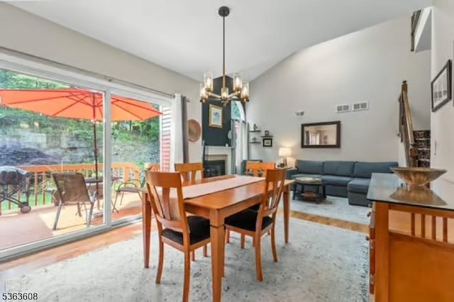 32 Ryan Ln, Lincoln Park Boro, NJ 07035 - dining space featuring lofted ceiling, a chandelier, light wood-type flooring, healthy amount of natural light, and a fireplace
