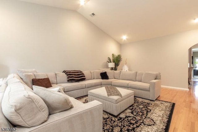 15 Fernwood Ct, Readington Twp, NJ 08889 - living room featuring arched walkways, vaulted ceiling, and light wood-style floors