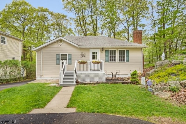 54 Stevens Trl, Hopatcong Boro, NJ 07843 - view of front facade featuring a chimney, a front yard, and a wooden deck