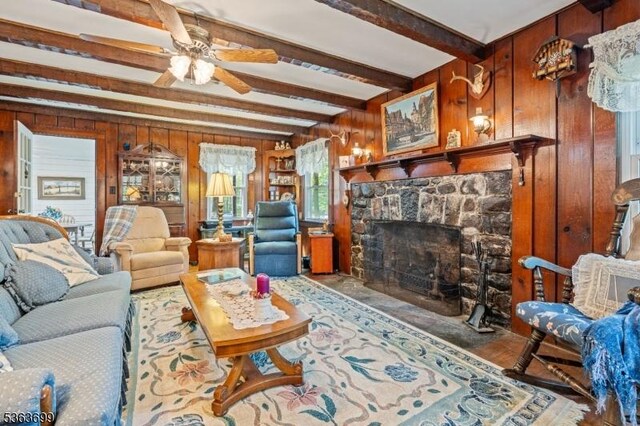 6 Penn Ave, Andover Twp, NJ 07860 - living area with wooden walls, beam ceiling, a stone fireplace, and ceiling fan