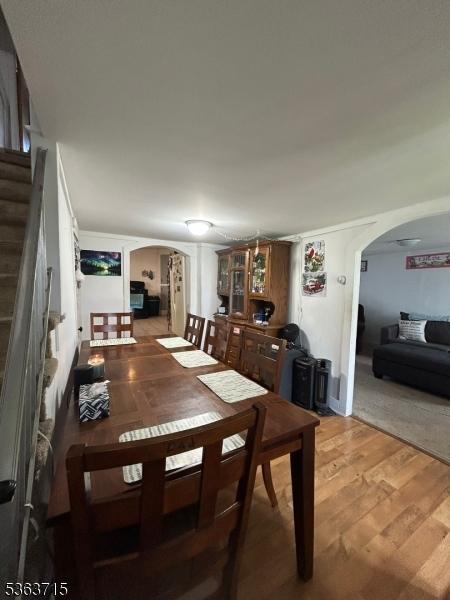 100 Myrtle Ave, Washington Boro, NJ 07882 - dining space with arched walkways, light wood-style floors, and stairway
